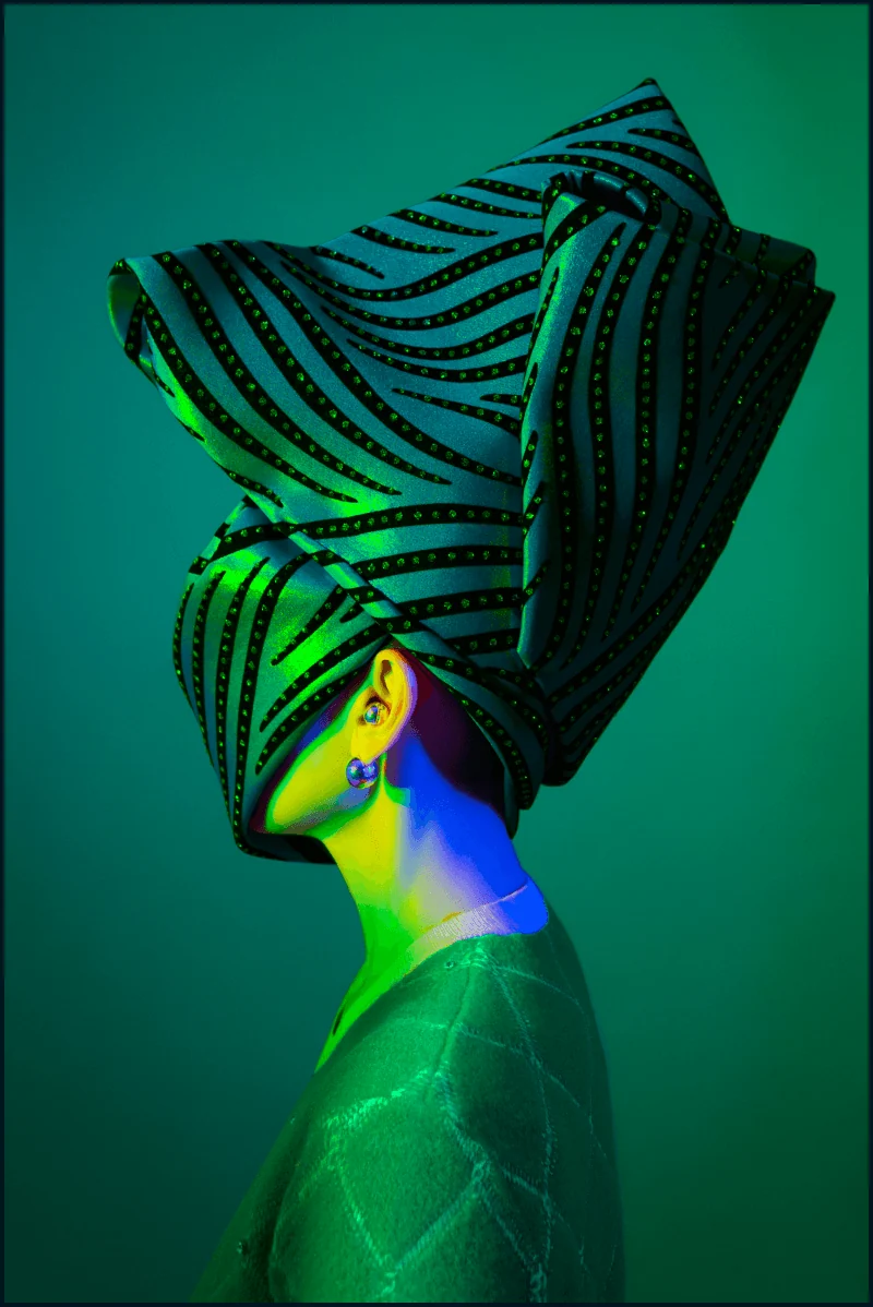 Metamorphoses Envoy portrait with a striped green headpiece and spectral light